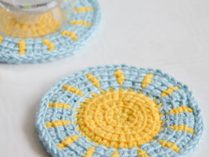 Little sun Tunisian crochet coaster pattern in use